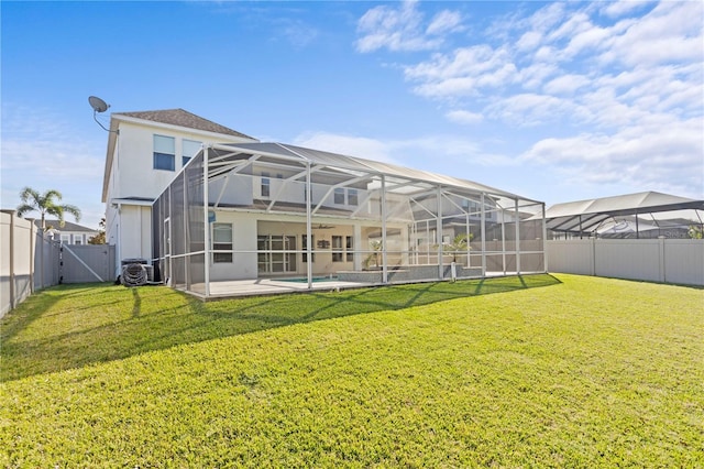 rear view of house with a yard and a lanai