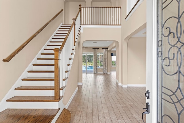 entryway with a high ceiling and light wood-type flooring