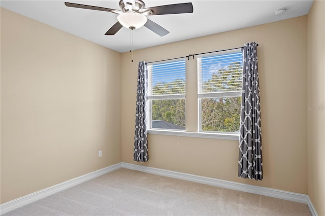 spare room with ceiling fan and carpet