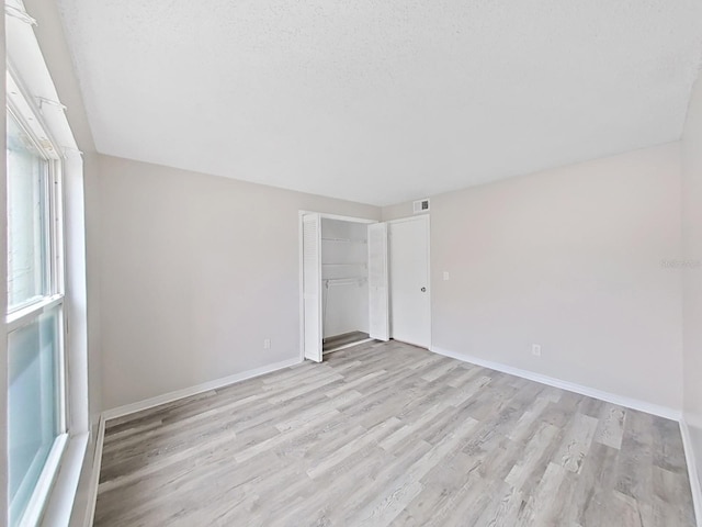 empty room featuring light hardwood / wood-style floors and a textured ceiling