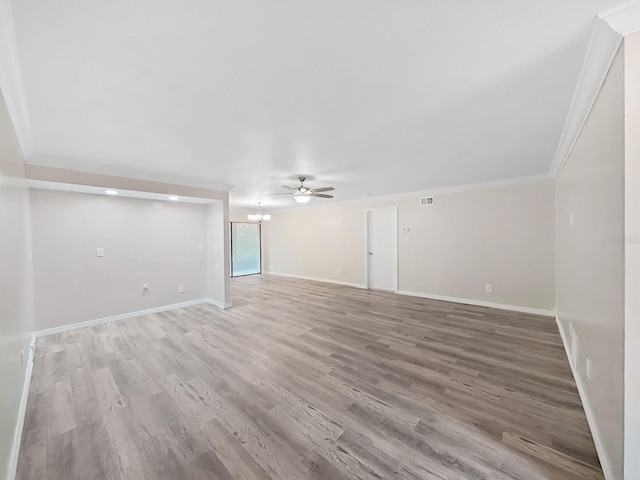 spare room with hardwood / wood-style flooring, ceiling fan with notable chandelier, and ornamental molding