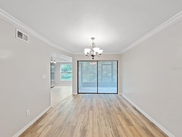 unfurnished dining area featuring crown molding, a chandelier, and light wood-type flooring