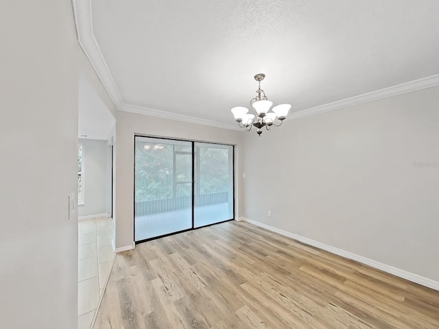 spare room featuring a textured ceiling, light wood-type flooring, crown molding, and an inviting chandelier