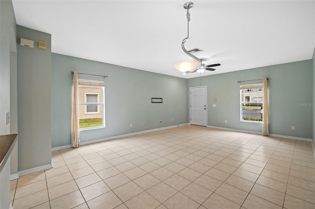 tiled empty room featuring ceiling fan