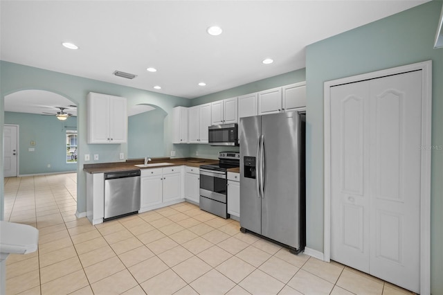 kitchen with sink, white cabinetry, light tile patterned floors, appliances with stainless steel finishes, and ceiling fan