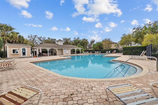 view of pool featuring an outbuilding and a patio