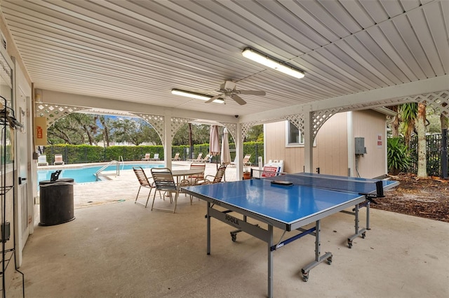 view of patio with a community pool and ceiling fan