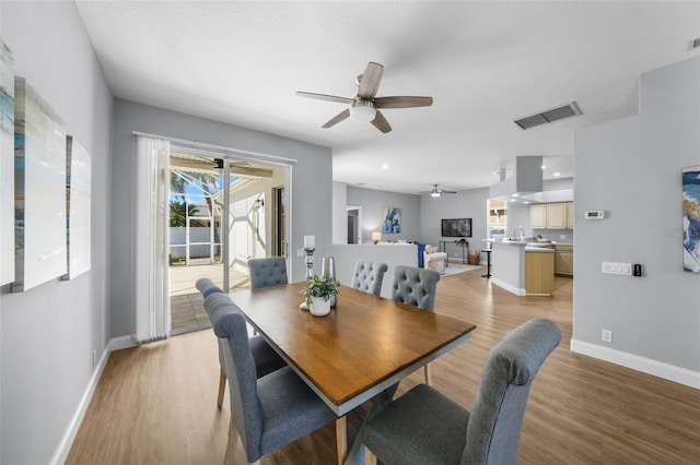 dining area with a textured ceiling, light hardwood / wood-style flooring, and ceiling fan