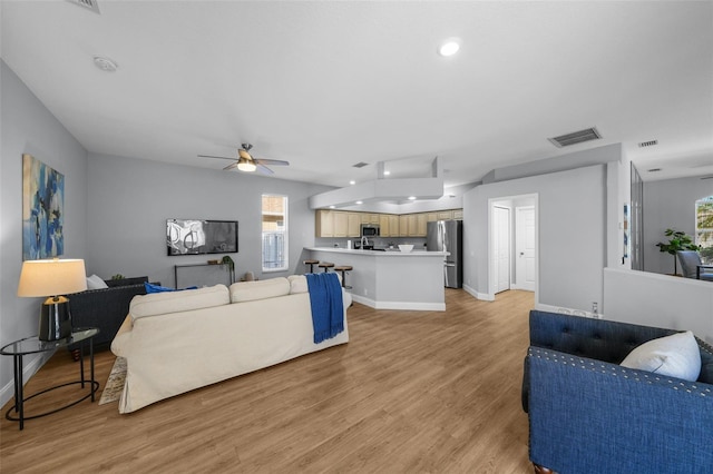 living room with ceiling fan, a wealth of natural light, and light hardwood / wood-style floors