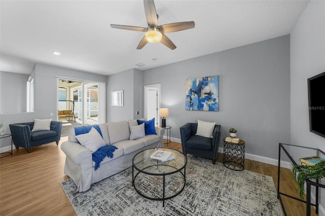 living room featuring wood-type flooring and ceiling fan