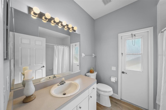 bathroom featuring vanity, toilet, curtained shower, and wood-type flooring