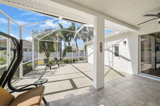 unfurnished sunroom with ceiling fan