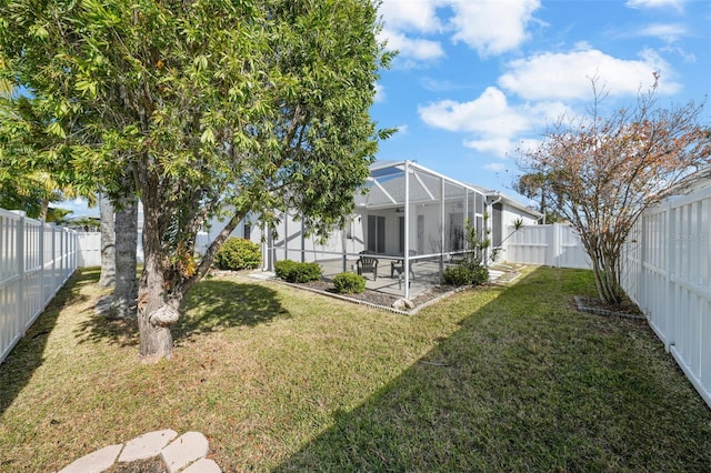 view of yard with glass enclosure and a patio area