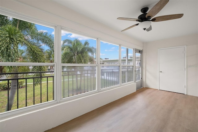 unfurnished sunroom featuring ceiling fan