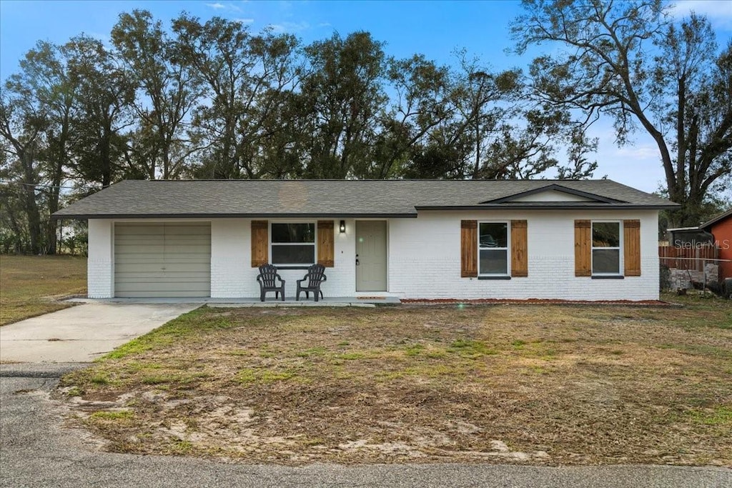 ranch-style home with a porch, a garage, and a front yard