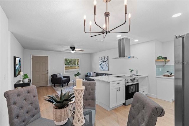 kitchen featuring decorative light fixtures, backsplash, white cabinets, island exhaust hood, and stainless steel range with electric cooktop