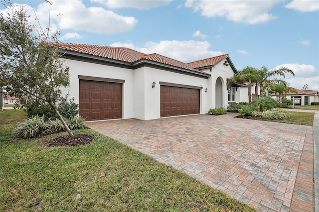 mediterranean / spanish-style home with a garage and a front yard