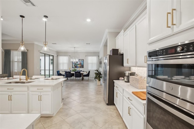 kitchen featuring pendant lighting, sink, stainless steel appliances, and white cabinets