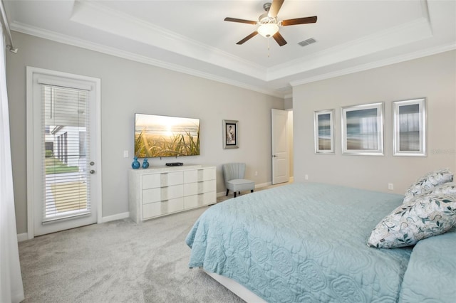 bedroom with light carpet, a tray ceiling, ornamental molding, and ceiling fan