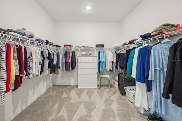 spacious closet featuring light colored carpet