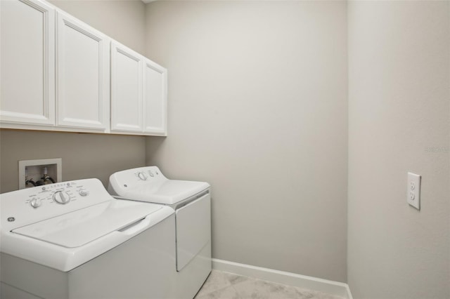 clothes washing area with cabinets and washing machine and dryer