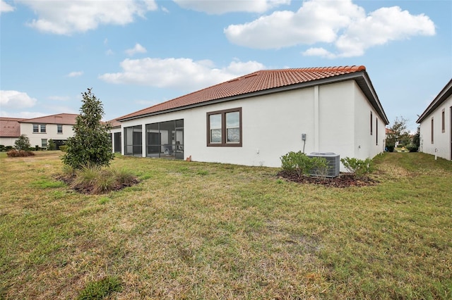 rear view of property with cooling unit, a yard, and a sunroom