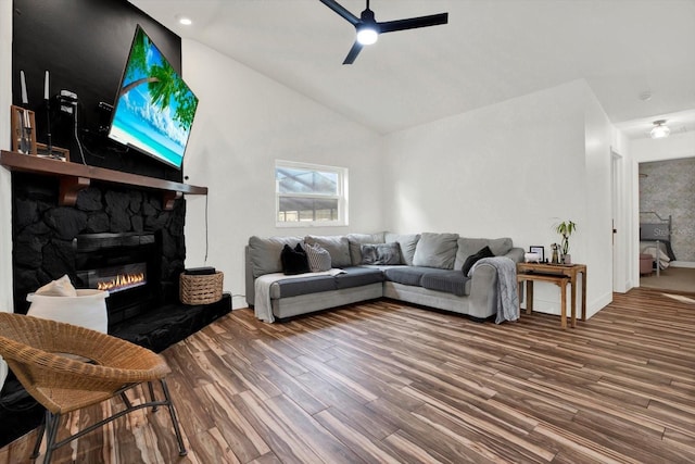 living room featuring hardwood / wood-style flooring, a stone fireplace, high vaulted ceiling, and ceiling fan