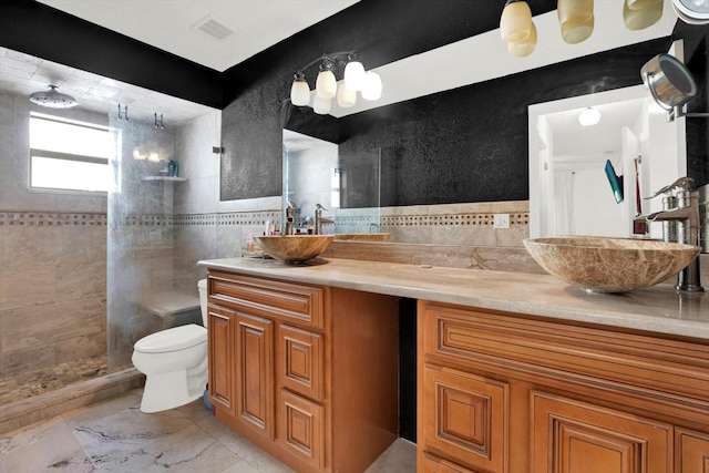 bathroom with vanity, a tile shower, and toilet