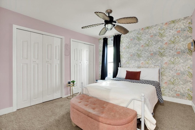 carpeted bedroom featuring multiple closets and ceiling fan