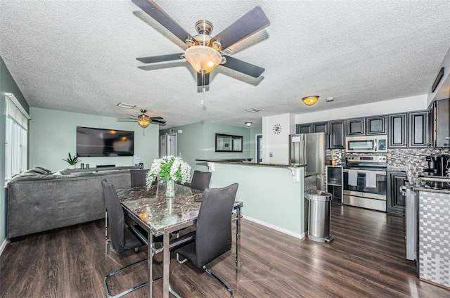 dining space with dark hardwood / wood-style floors and a textured ceiling