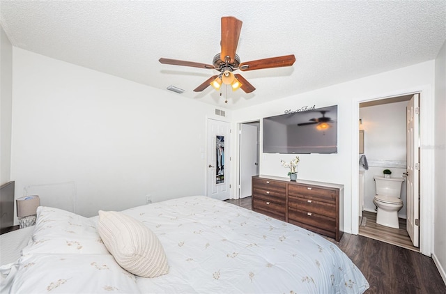 bedroom with connected bathroom, a textured ceiling, dark hardwood / wood-style floors, and ceiling fan