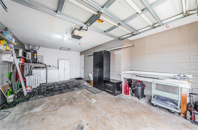 garage with electric water heater, a garage door opener, and washer and dryer