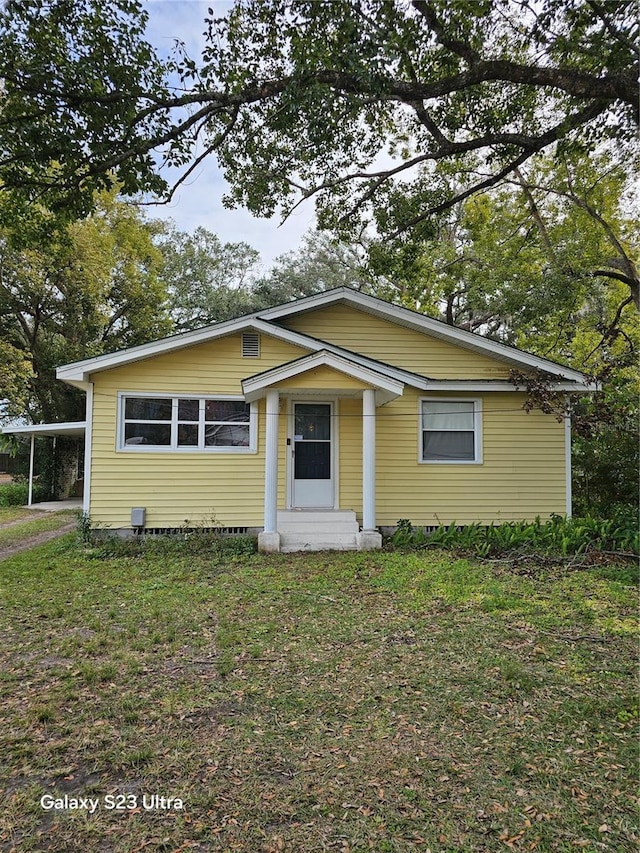 view of front of house featuring a carport and a front lawn