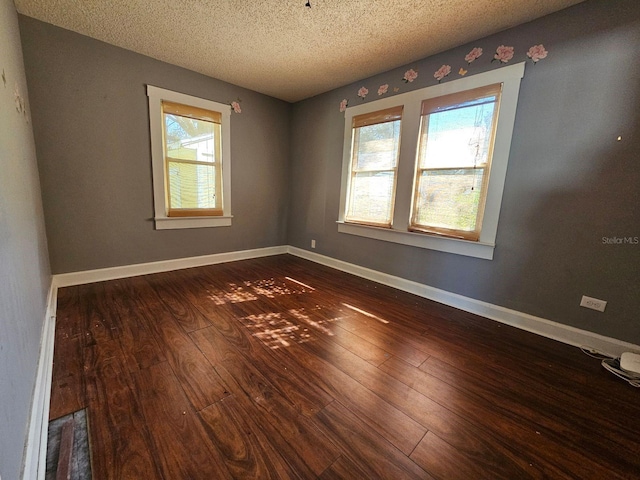 unfurnished room featuring dark hardwood / wood-style floors and a textured ceiling