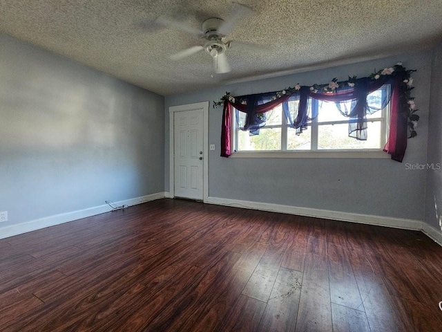 empty room with ceiling fan, dark hardwood / wood-style floors, and a textured ceiling