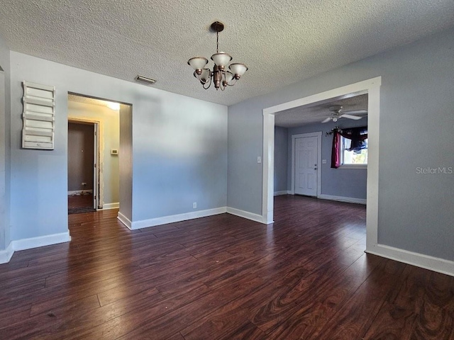 empty room featuring dark hardwood / wood-style floors, ceiling fan with notable chandelier, and a textured ceiling