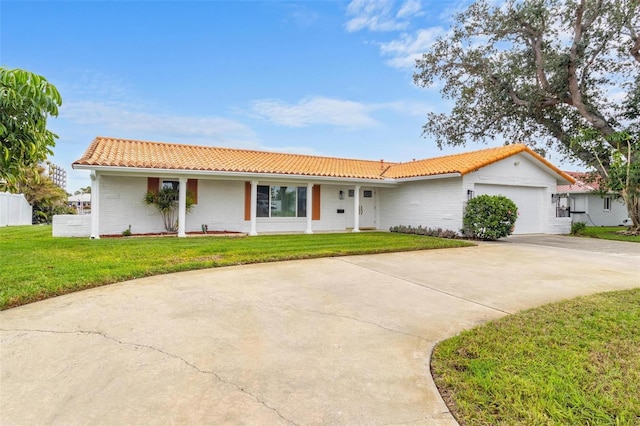 ranch-style house featuring a garage and a front lawn