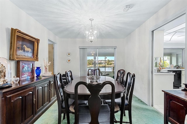 carpeted dining area with a chandelier and a water view