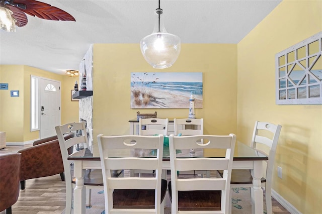 dining area with light hardwood / wood-style flooring and a textured ceiling