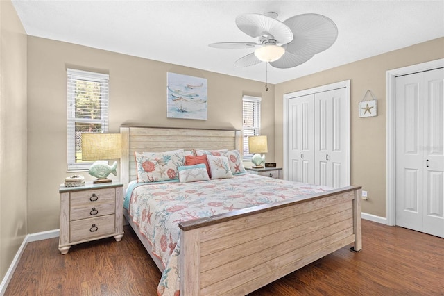 bedroom featuring dark wood-type flooring, two closets, and ceiling fan