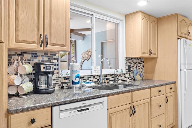 kitchen with tasteful backsplash, white appliances, sink, and light brown cabinets