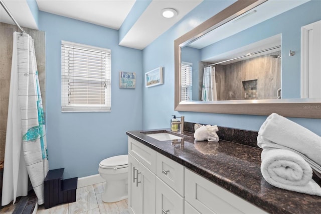 bathroom with vanity, plenty of natural light, toilet, and walk in shower