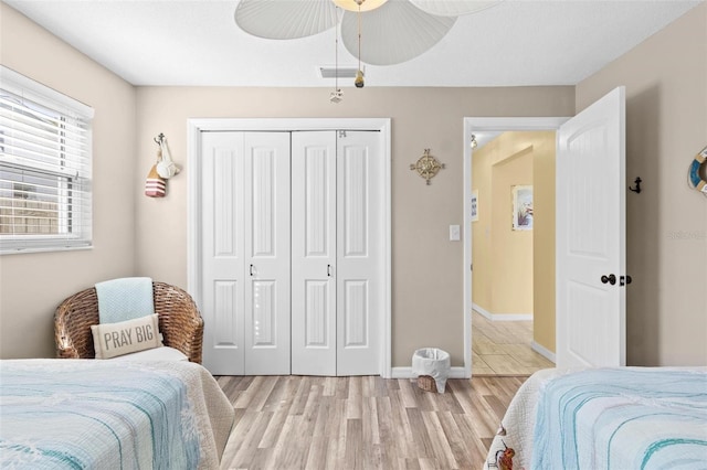 bedroom featuring light hardwood / wood-style floors, a closet, and ceiling fan