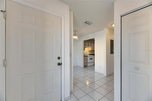 hallway featuring visible vents and light tile patterned flooring