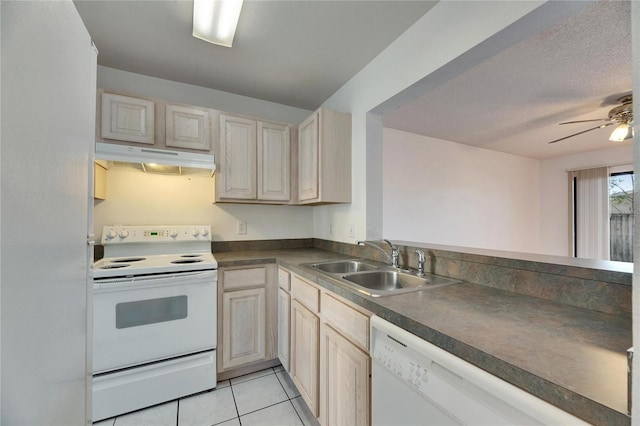 kitchen featuring light tile patterned floors, under cabinet range hood, white appliances, a sink, and dark countertops