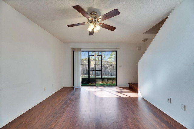 spare room featuring a ceiling fan, a textured ceiling, baseboards, and wood finished floors