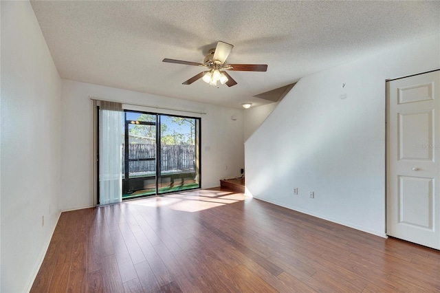 empty room with ceiling fan, a textured ceiling, and wood finished floors