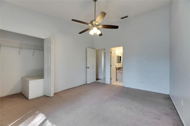 unfurnished bedroom featuring visible vents, a ceiling fan, connected bathroom, light colored carpet, and a closet