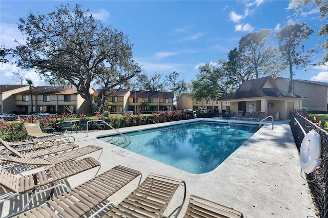 pool with a residential view, a patio, and fence