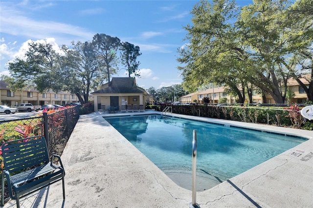 community pool with fence and a patio